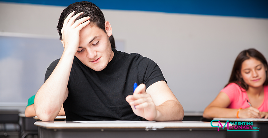Young man struggling over an exam.