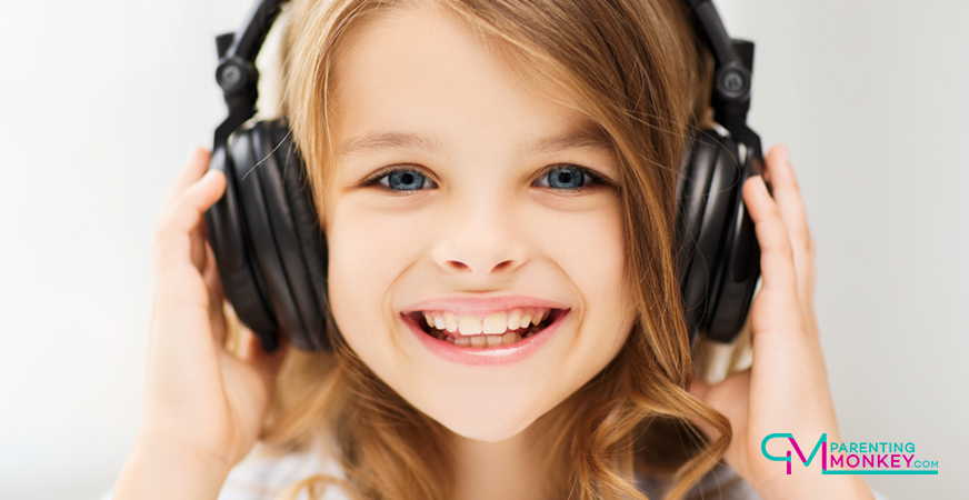 Girl, smiling listening to music with large headphones.